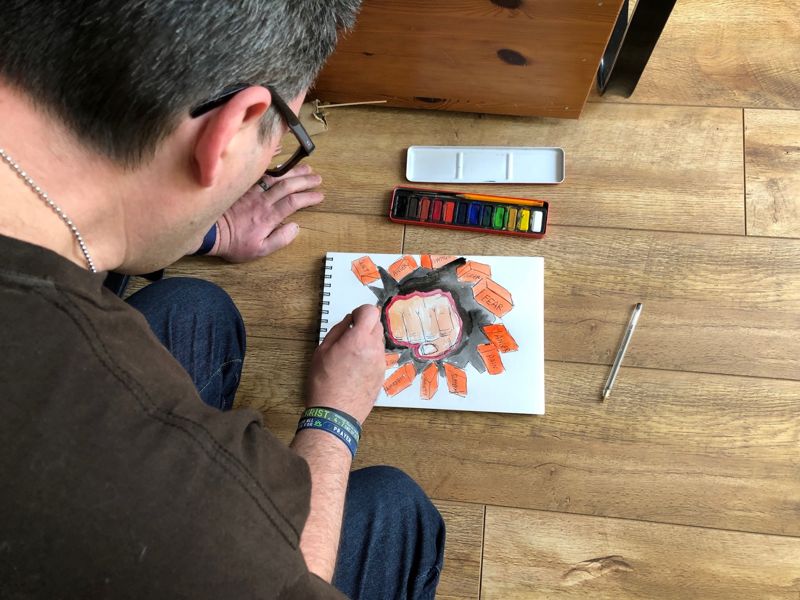 Jason painting a prophetic drawing on the floor